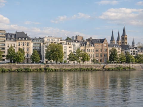 Wohnhäuser verschiedener Baujahre an einer Uferpromenade am Rhein