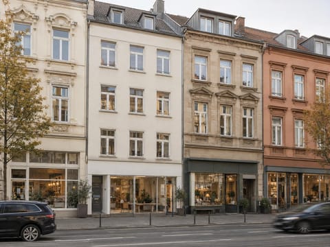 Wohn- und Geschäftshäuser verschiedener Baujahre mit Läden im Erdgeschoss an einer Hauptstraße